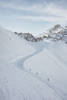 two people are skiing down a snowy mountain