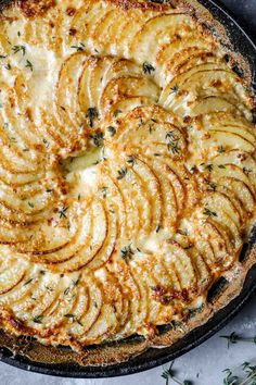 a baked dish with potatoes and herbs on top