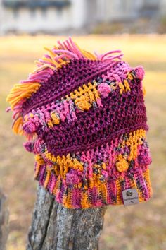 a knitted hat sitting on top of a tree stump