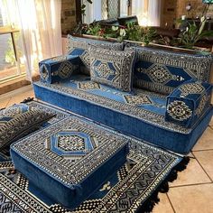 a blue couch and ottoman sitting on top of a tile floor