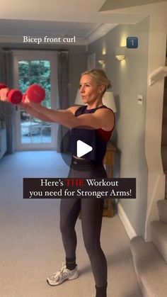 a woman holding two red dumbs while standing in front of a wall with the words here's the workout you need for strong arms