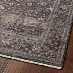 an area rug on the floor with wooden floors and dark colored colors, including blue