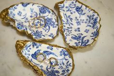 three pieces of blue and white porcelain with gold trimmings on them, including two wedding rings