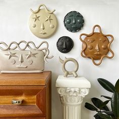 several decorative items are displayed on the wall next to a planter and other objects