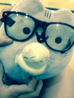 a person holding a stuffed animal with glasses on it's face and smiling at the camera