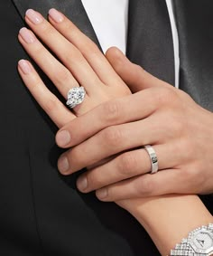 a man and woman's hands wearing wedding rings