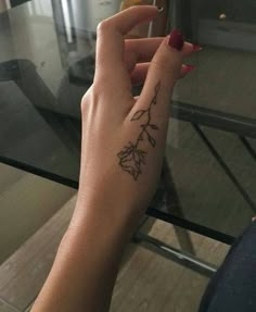 a woman's hand with a small tattoo on it