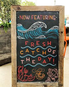 a chalkboard sign advertising fresh catch of the day