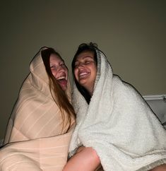 two women wrapped in towels are laughing together