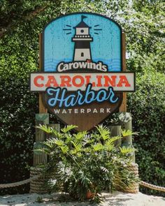 a sign for the carolina harbor waterpark in front of some trees and bushes,