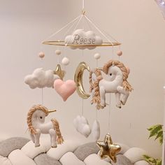 a baby mobile with unicorns, stars and moon hanging from it's sides