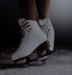 a pair of white ice skates with brown laces