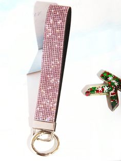 a pair of scissors with pink sequins on it and a keychain