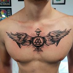 a man with an angel tattoo on his chest and wings around the triangle, surrounded by other symbols