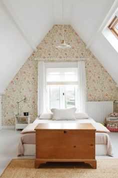 a bed sitting under a window in a bedroom