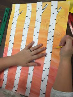 a woman is painting trees with acrylic paint and pencils on the table