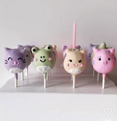 there are five cake pops with animals on them and one has a candle in the middle