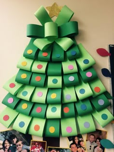 a christmas tree made out of green paper with pictures on the bottom and polka dots