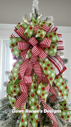 a christmas tree decorated with green and red ribbons, polka dot bows and pine cones