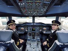 two pilots are sitting in the cockpit of an airplane with their hands on their hipss