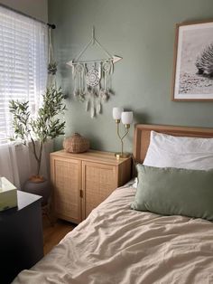 a bedroom with green walls and white curtains