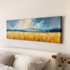 a painting hanging on the wall above a bed in a room with white sheets and pillows