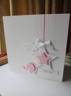 a card with a pink elephant and star on the front, sitting on a table