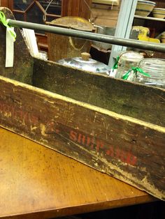 an old wooden box sitting on top of a table next to some jars and other items