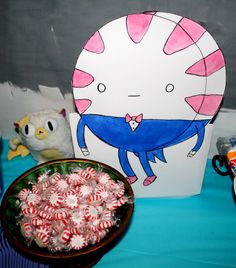 a table topped with lots of candy canes next to a paper plate and cup