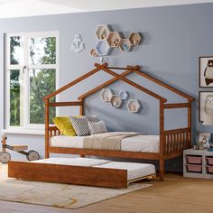 a child's bedroom with blue walls and wooden furniture, including a bed frame