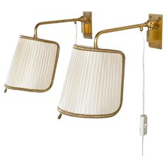 Pair of beautiful 1950's Italian Brass Wall Lamps with fabric shades. Set on a brass wall mount with swiveling brass arm. Cream and gold pleated fabric shades with teardrop brass knob to direct the shades for the desired lighting. Ideal for hallway or bedside lighting. Swiss plug with mid cable on/off switch. Measurements: Height: ca. 20cm  Depth : 30cm Shade - Width: 16cm  Height: 18cm Colour: Gold / Cream Condition: Excellent condition with minimal signs of use. In full working condition. Brass Wall Lamp, Lamps For Sale, Bedside Lighting, Brass Knobs, Pleated Fabric, Cream And Gold, Glass Plates, Modern Table Lamp, Modern Table