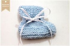 two blue knitted baby mittens tied together