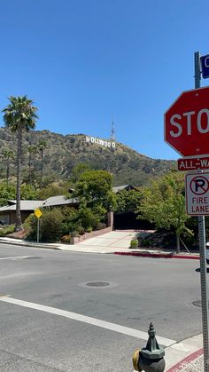 a red stop sign sitting on the side of a road next to a fire hydrant