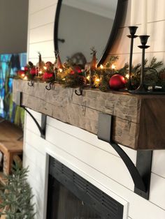 a fireplace mantle decorated for christmas with candles and ornaments