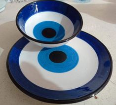 two blue and white bowls sitting on top of each other in the shape of an eye