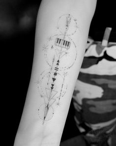 a black and white photo of a person's arm with a tattoo on it