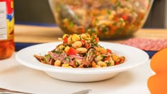 a white bowl filled with food on top of a table next to utensils