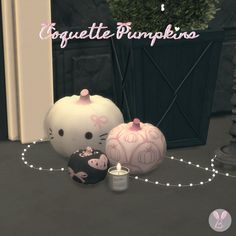 two hello kitty pumpkins sitting next to each other on a table with candles in front of them