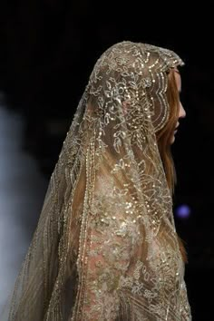 a woman in a veil walks down the runway