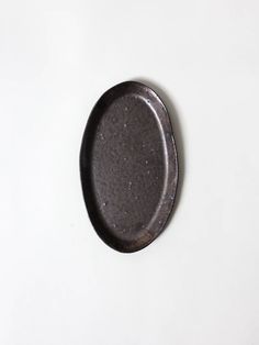 a black plate sitting on top of a white table