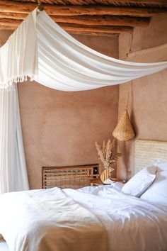 a bed with white sheets and pillows in a bedroom next to a wall mounted wicker basket