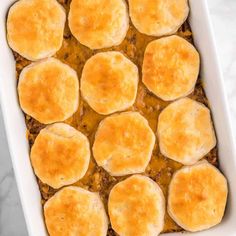 a casserole dish filled with meat and cheese on top of a marble counter