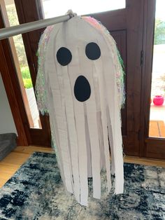 a paper bag with a ghost face on it and some other decorations hanging from the front door