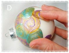 a hand holding an ornament that has been painted