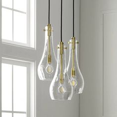 three glass light bulbs hanging from a ceiling