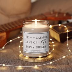 a candle sitting on top of a table next to a string of lights and a guitar