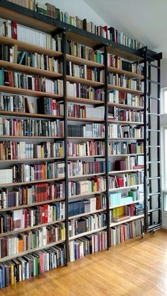 a large book shelf filled with lots of books on top of a hard wood floor