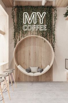 the interior of a coffee shop with plants growing on the wall and round seating area