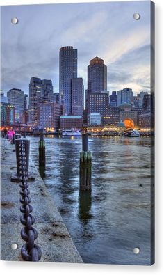 the city skyline is lit up at night from across the river acrylic print on canvas