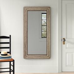 a chair sitting in front of a mirror on the wall next to a wooden table